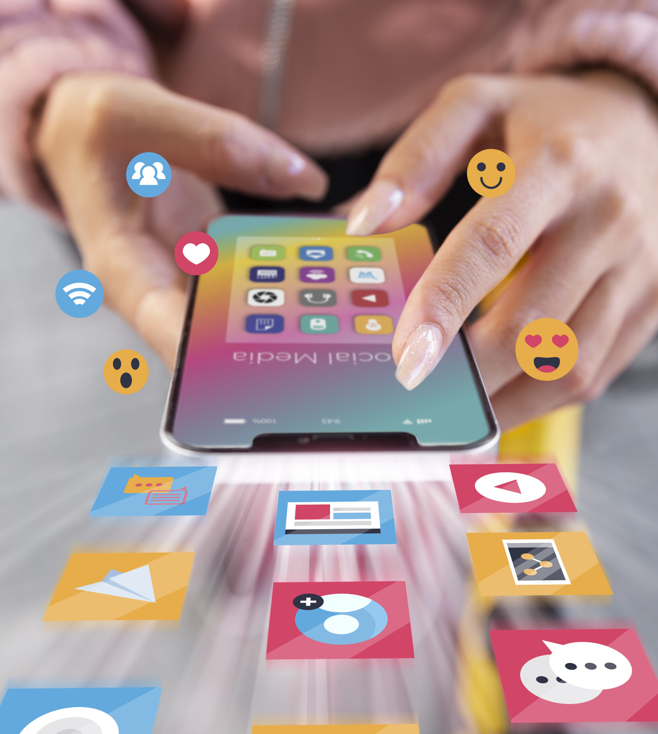 Close-up of a person interacting with a smartphone displaying social media apps, with colorful digital icons and emojis emerging from the screen.