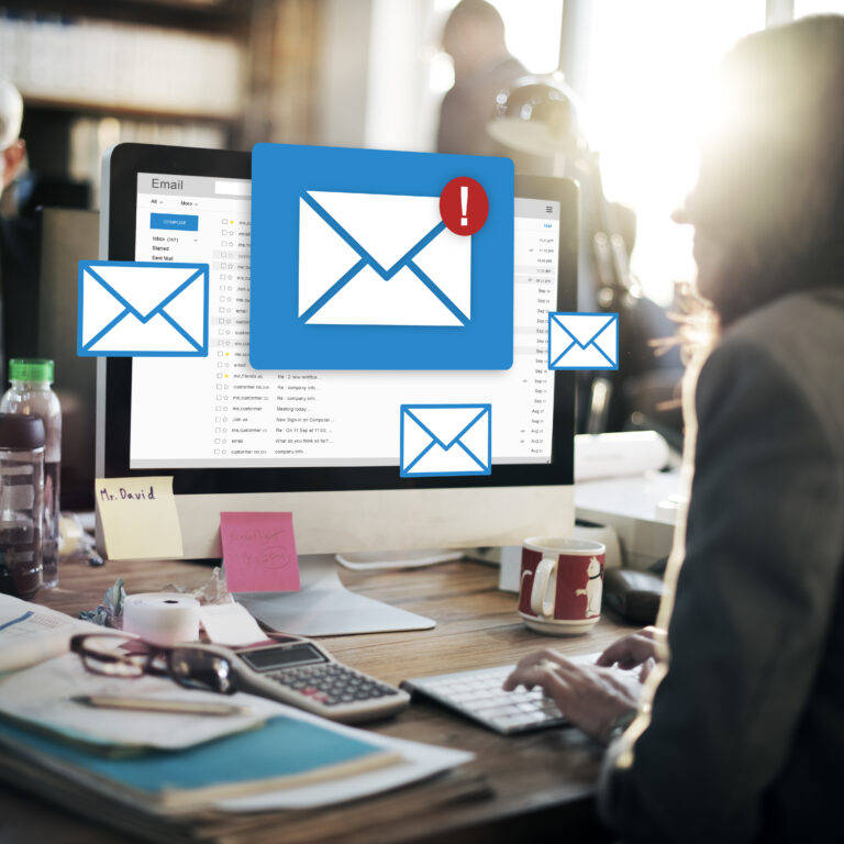 Professional managing email marketing campaigns on desktop with email notifications on screen