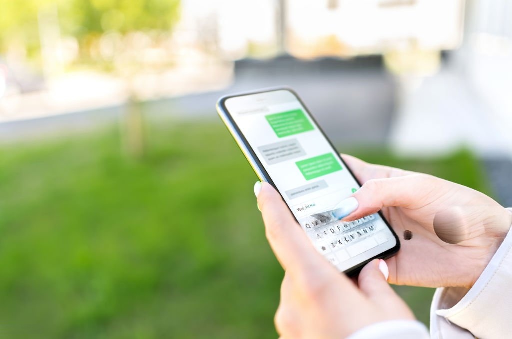 Person sending a text message on a smartphone, representing SMS marketing communication