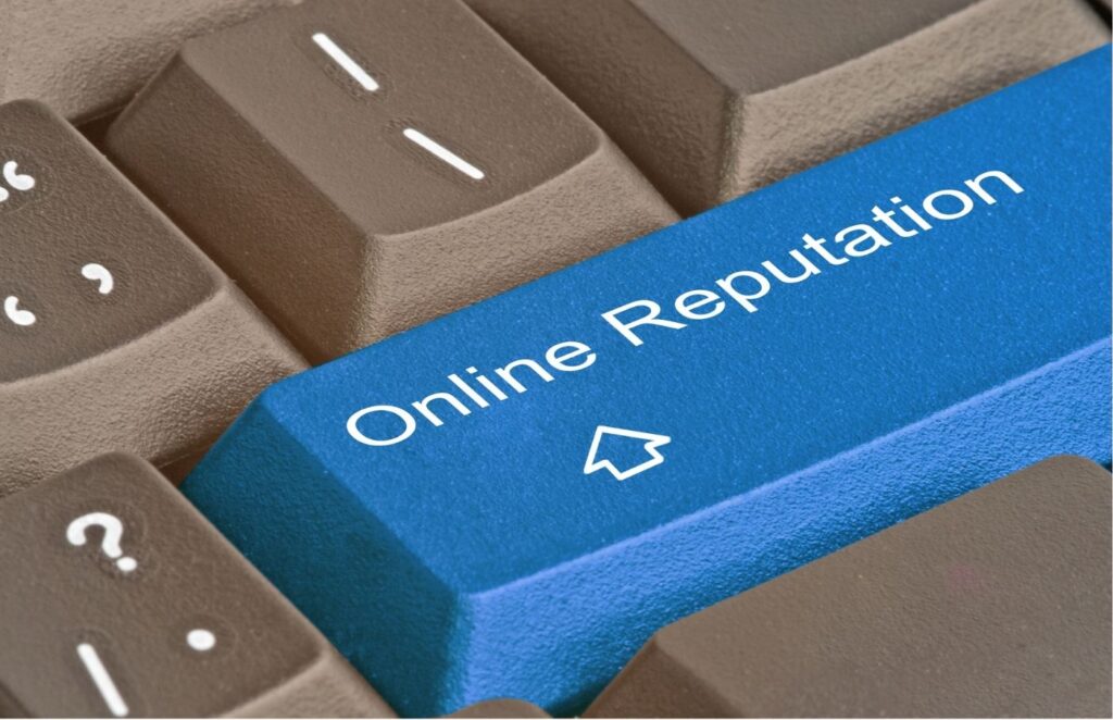 A close-up of a computer keyboard with a prominent blue key that reads 'Online Reputation