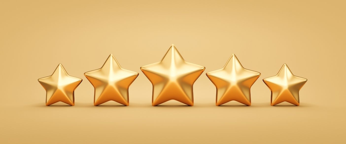 Five gleaming golden stars in a row on a smooth gold background