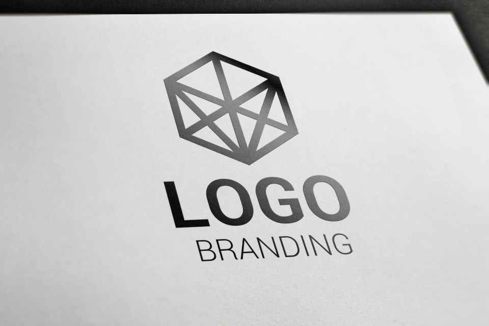 A sample logo design featuring a geometric polygonal shape above the words 'LOGO' and 'BRANDING' on a white background
