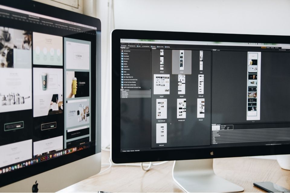 Computer screen displaying UI/UX design software with wireframes and designs