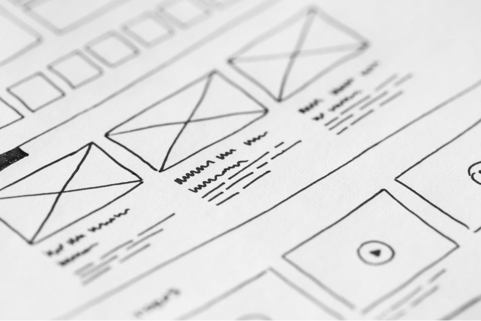 Close-up of hand-drawn website or app wireframes on paper