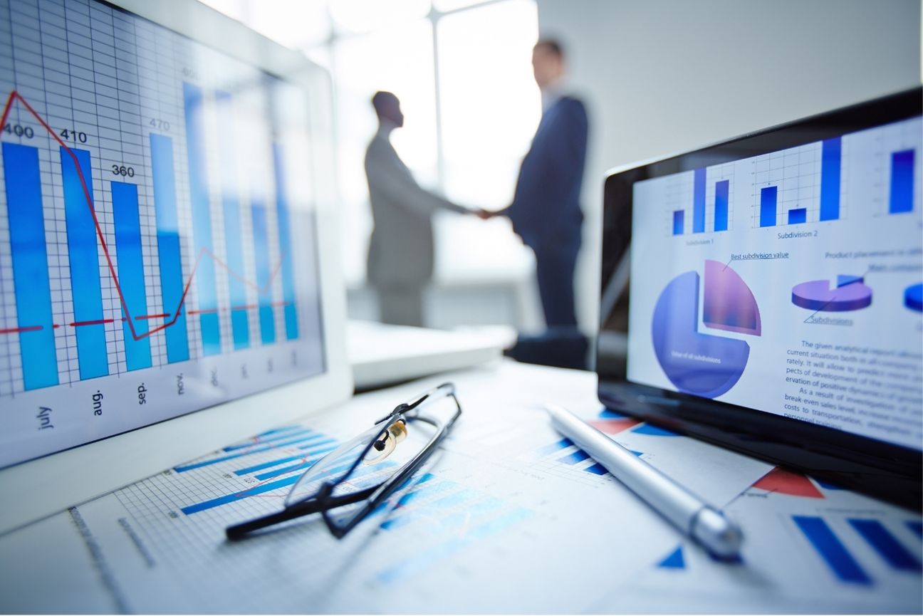 Business meeting with analytics charts on a desk, tablet displaying marketing graphs, symbolizing data-driven LinkedIn marketing strategy