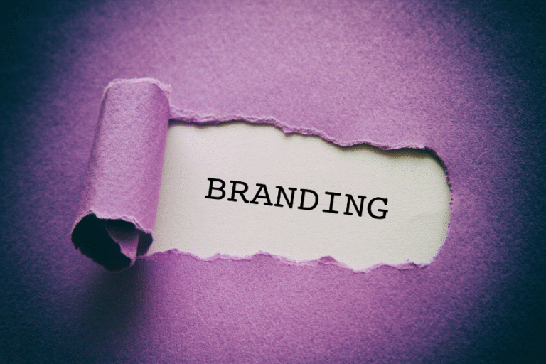 The word 'BRANDING' revealed through a torn purple paper, on a white background