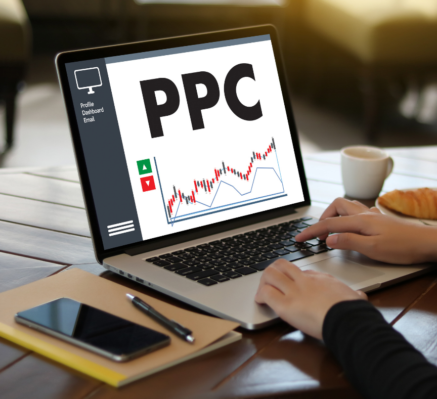 Hands typing on a laptop displaying a PPC dashboard with a graph and a prominent 'PPC' text