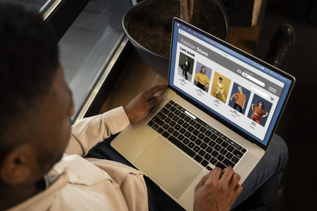 A person shopping for clothes online on a fashion store website using a laptop