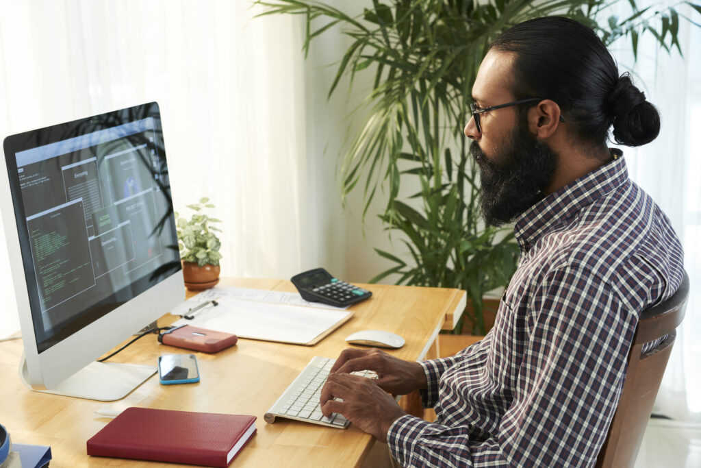 An experienced developer from a website development company , meticulously programming a new software application at his workstation
