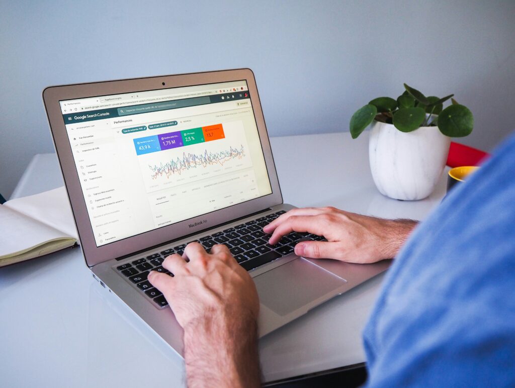 A person working on a laptop with the Google Search Console performance report open on the screen