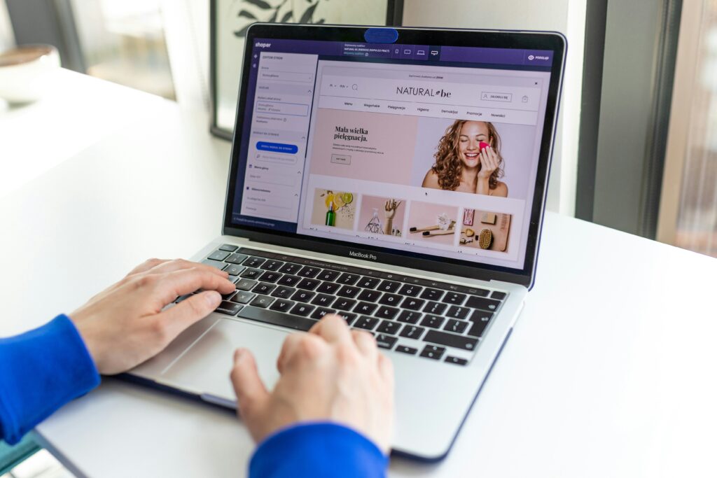 Person designing an online store on a laptop using an e-commerce platform