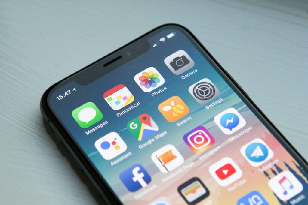 Close-up of a smartphone screen displaying various mobile app icons such as Messages, Photos, Camera, Google Maps, Instagram, and Facebook